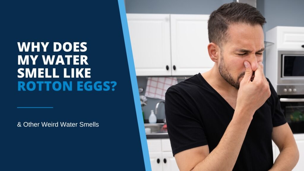 Man in black t-shirt stands in front of kitchen sink holding nose and grimacing, illustrating blog post, “Why Does My Water Smell Like Rotten Eggs? & Other Weird Water Smells.”